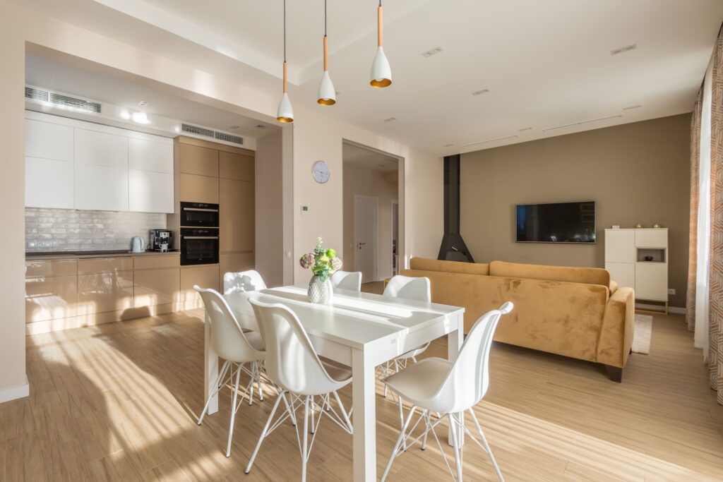Bright, open-concept residential interior featuring a dining area, modern kitchen, and warm natural light.